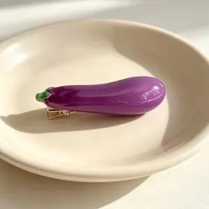 Macro view of a realistic glossy purple eggplant hair clip resting on a beige ceramic plate