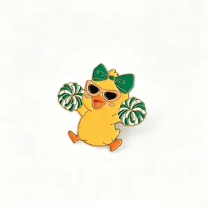Vibrant detail of a cute cheerleader duck enamel pin with sunglasses and pom-poms.