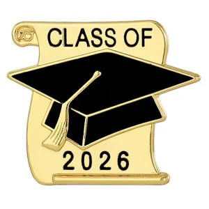 Primer plano del broche de graduación dorado con birrete negro y texto Class of 2026