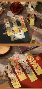 Detailed view of elegant hollowed-out golden metal bookmarks with colorful floral designs.