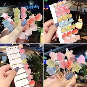 Detail of gradient gummy-style heart and star hair clips with frosted sugary texture