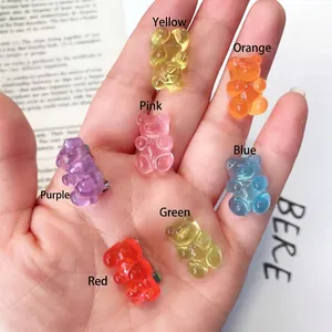 Hand showing seven colorful gummy bear resin brooches in candy shades