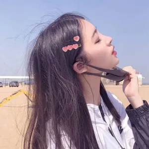 Model wearing cute gradient pink heart-shaped hairpins in a sunny beach setting