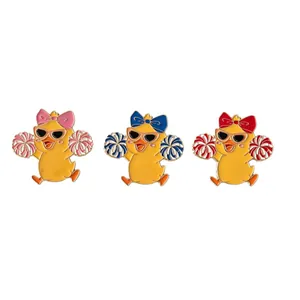 Set of three cute cartoon cheerleader duck enamel pins with vibrant colorful bows