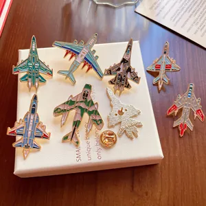 Detailansicht verschiedener Militärflugzeug-Emaille-Anstecknadeln auf einer Geschenkbox