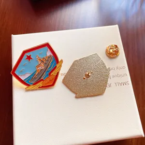 Close-up of military navy ship metal brooch with red star on textured white jewelry box