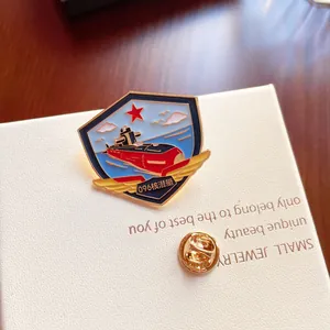 Detailed macro view of a shield-shaped metal submarine badge with golden wings and red star