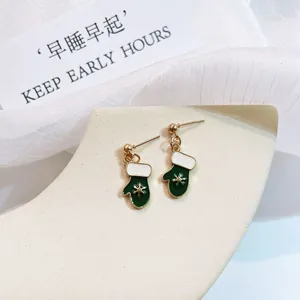 Detail of green enamel Christmas mitten earrings with 925 silver needles and snowflake
