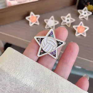 Close-up of a star-shaped volleyball enamel pin badge with a starry cosmic background