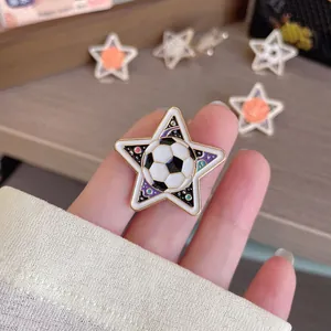 Macro view of a five-pointed star enamel brooch featuring a soccer ball design