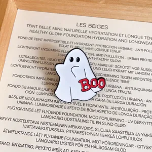 Detailed close-up of a cute white ghost enamel pin featuring red BOO text for Halloween.