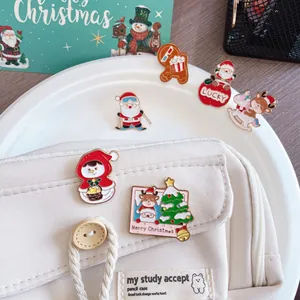Detailed close-up of festive Santa and reindeer enamel pins on a white canvas case
