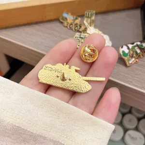 Detailed view of the gold-colored metal tank pin back with butterfly clutch fastener