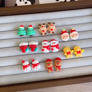 Detailed view of various colorful Christmas cartoon earrings on a grey jewelry display tray.