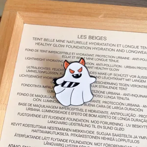 Detailed close-up of a white Halloween ghost enamel pin with orange horns