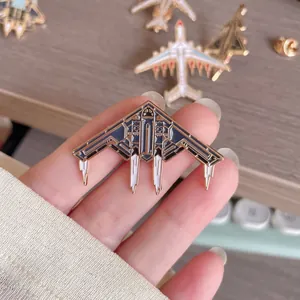 Detailaufnahme eines metallischen Emaille-Pins in Form eines Tarnkappenbombers