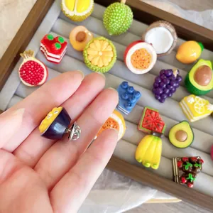 Detailed view of 3D fruit resin brooches showing metal pin back and colorful fruit shapes