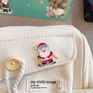 Detailed shot of a cute skiing Santa Claus metal brooch on a white canvas background