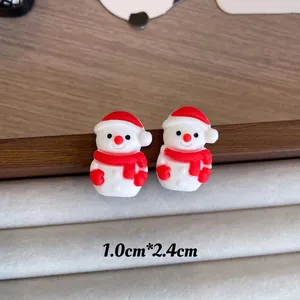 Detail view of cute red and white snowman Christmas stud earrings measuring 1.0cm by 2.4cm