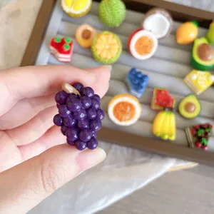 Detailed close-up showing a realistic purple resin grape brooch with a glossy finish.