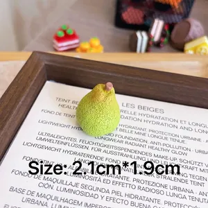 Macro detail showing realistic texture of miniature pear resin brooch on wooden tray