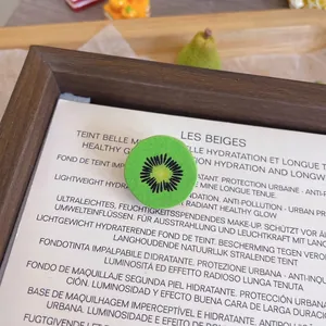 Close-up detail of a cute 3D resin kiwi fruit slice brooch pin for clothing decoration