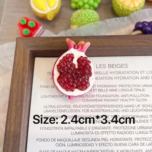Detailed macro shot of a cute handmade resin pomegranate fruit brooch badge accessory