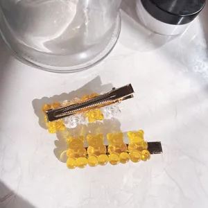 Close-up detail of high transparency gummy bear charms on cute gold-tone hair clips