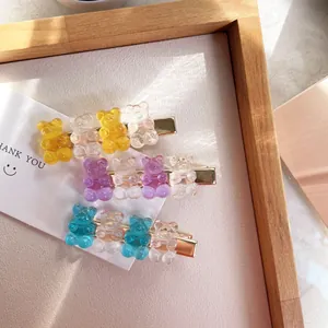 Close-up of cute transparent gummy bear hair clips in candy colors with gold metal