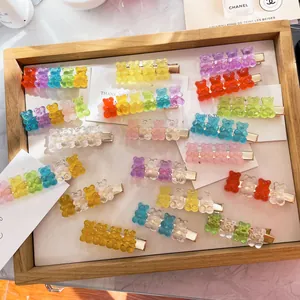 Detail view of colorful translucent gummy bear hair clips arranged in a wooden tray