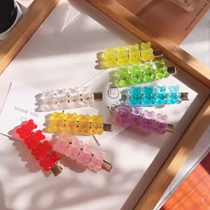 Macro detail of transparent gummy bear hair clips in multiple vibrant candy colors.