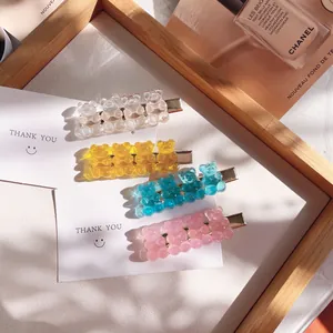 Macro view of cute transparent candy-colored bear hair clips in a stylish gift tray