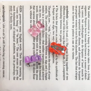 Detail view of cute gummy bear pins in pastel colors on vintage paper background.