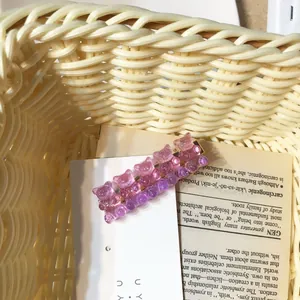 Detail view of cute glitter gummy bear hair clip on vintage book prop background