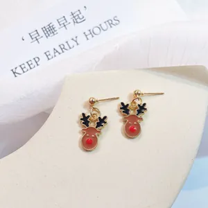 Close-up of Christmas reindeer drop earrings with red nose detail on display stand.