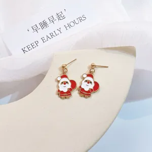 Close-up view of cute enamel Santa Claus earrings with gold finish and silver needles.