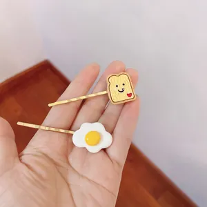 Detailed view of handmade simulation food hairpins with toast and fried egg designs