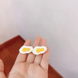 Detailed close-up shot of a cute realistic poached egg hair clip held in a hand for scale