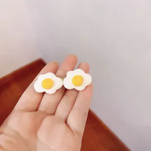 Detailed macro view of a cute simulation poached egg hair clip held in a hand display