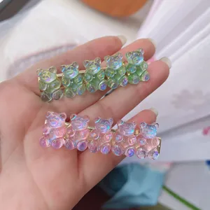 Close-up of cute gummy bear hair clips in iridescent pink and green resin material