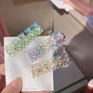 Detailed view of three colorful gummy bear hair clips mounted on a white display card.