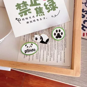 Gros plan détaillé de pins en émail panda avec bordure verte et motif de patte