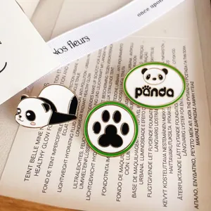 Vue détaillée de pins en émail panda avec artisanat en métal et design de patte avec bord vert