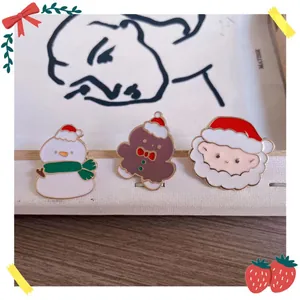 Macro view of cute cartoon Christmas enamel pins with Santa Claus and snowman motifs.