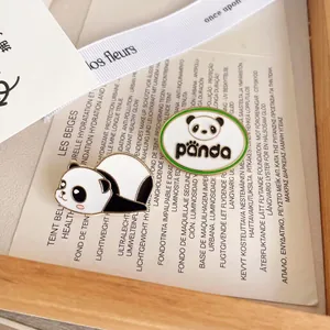 Détail d'une mignonne broche en émail de panda et d'un badge panda sur fond esthétique