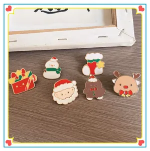 Detail view of colorful cartoon Christmas enamel pins with Santa and reindeer motifs.