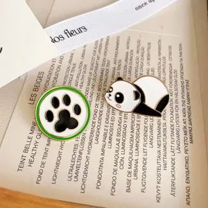 Gros plan détaillé de broches en émail de panda et de patte sur un fond de carte décoratif.