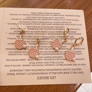 Vista detallada de los pendientes de raqueta de ping-pong rosa con detalles de perlas