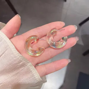 Dettaglio degli orecchini in acrilico a forma di C con lucentezza iridescente