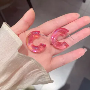 Dettaglio ravvicinato di orecchini a cerchio a C in acrilico rosa cangiante effetto sirena